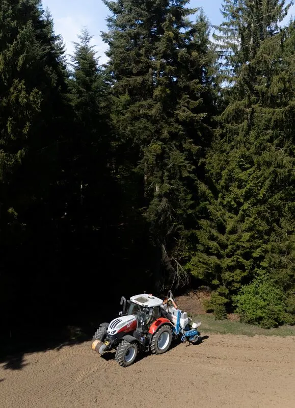 Traktor am Waldrand von oben