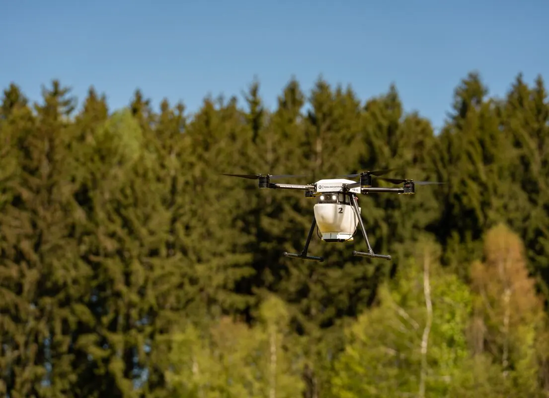 Agrardrohne im Flug vor dem Waldrand